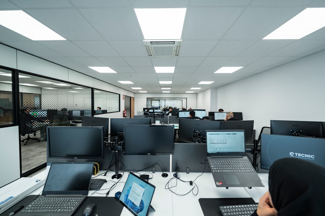 who-we-are General view of a technical office with several employees working on computers in a modern and orderly environment.